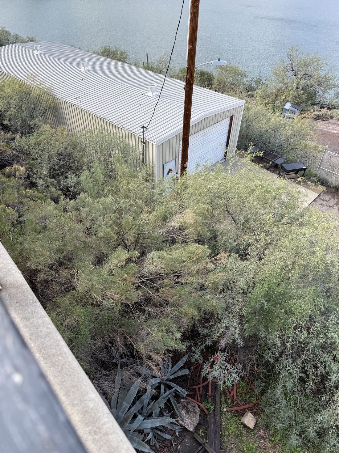 Overgrown vegetation cleared from beneath a power line corridor next to a utility building in Arizona